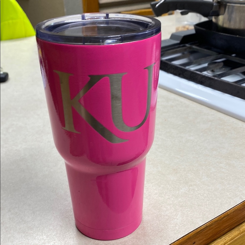 Pink and Silver RTIC brand Coffee/Tea cup with a Jayhawk logo